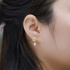 Golden Flora Pearl Studs featuring delicate gold flowers and a classic pearl drop, embodying timeless elegance.