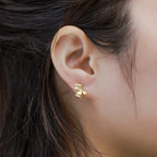 Golden Flora Pearl Studs featuring delicate gold flowers and a classic pearl drop, embodying timeless elegance.
